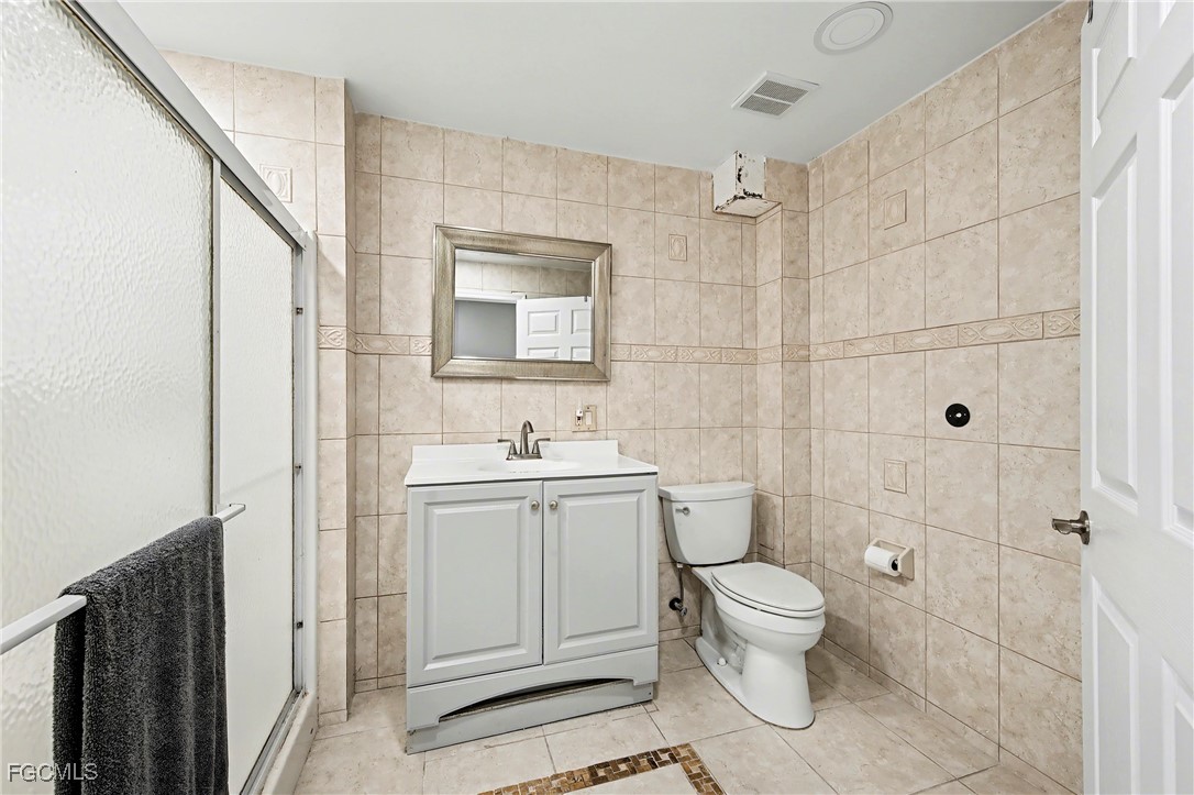 285 Dundee Road Fort Myers Beach, FL 33931 - Photo 20 of 42 a bathroom with a toilet sink vanity and mirror