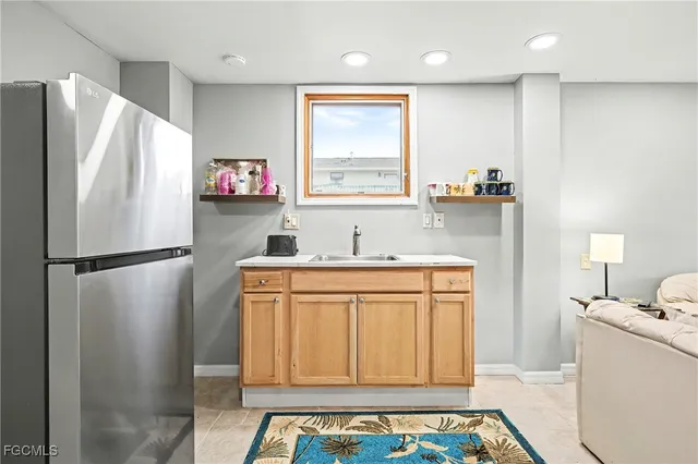 a kitchen with stainless steel appliances a refrigerator sink and wooden floor