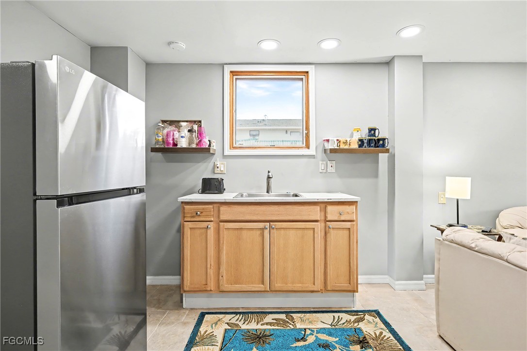 285 Dundee Road Fort Myers Beach, FL 33931 - Photo 23 of 42 a kitchen with stainless steel appliances a refrigerator sink and wooden floor