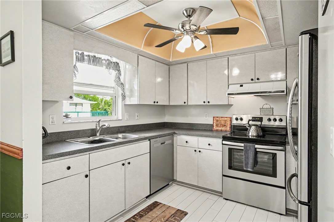 285 Dundee Road Fort Myers Beach, FL 33931 - Photo 5 of 42 a kitchen with stainless steel appliances granite countertop a sink a stove a refrigerator and cabinets