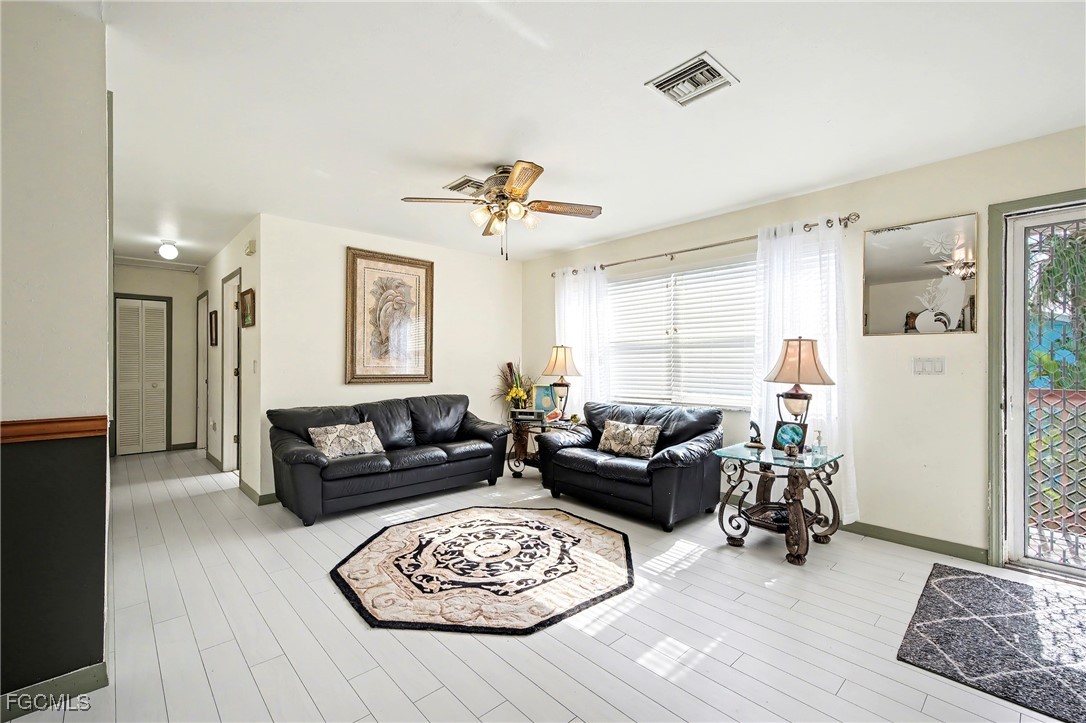 285 Dundee Road Fort Myers Beach, FL 33931 - Photo 10 of 42 a living room with furniture a rug and a chandelier
