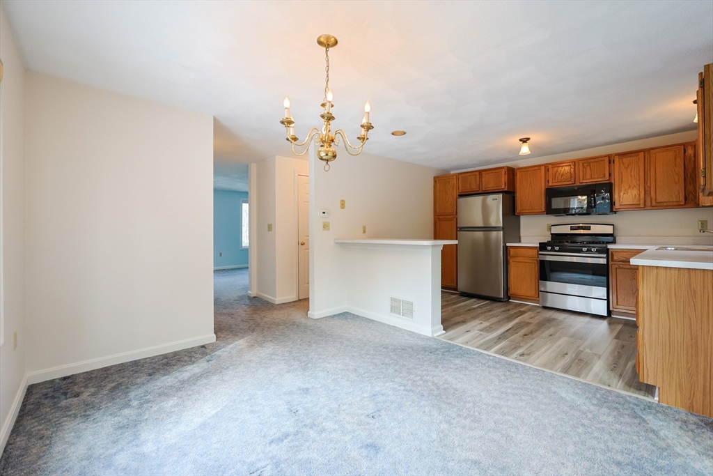 22 Deer Path, Unit 6 Maynard, MA 01754 - Photo 17 of 34 a view of a kitchen with a sink and dishwasher a refrigerator with wooden floor