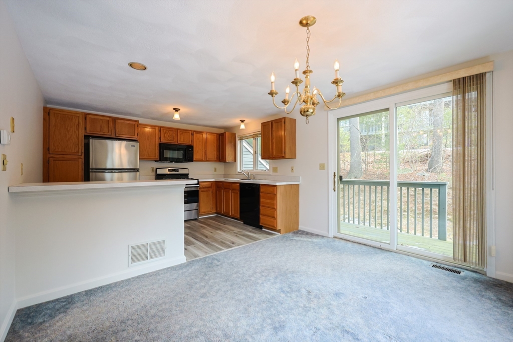 22 Deer Path, Unit 6 Maynard, MA 01754 - Photo 2 of 34 a view of a kitchen with a sink cabinet and a living room