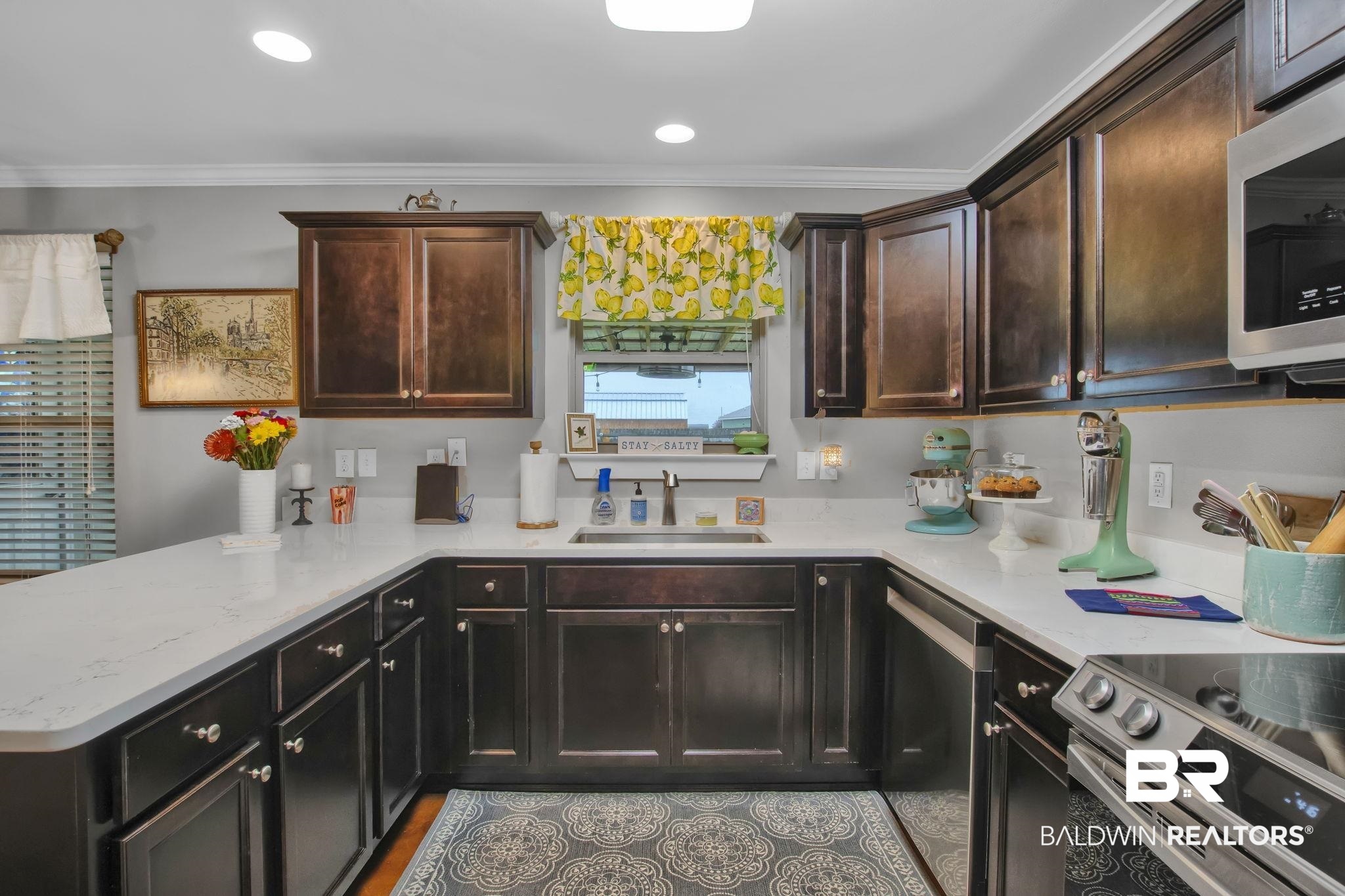 203 Lakefront Circle Summerdale, AL 36580 - Photo 23 of 69 Kitchen with ornamental molding, sink, kitchen peninsula, dark brown cabinets, and appliances with stainless steel finishes