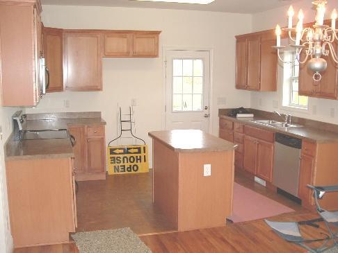 3802 Morgans Mill Road Goodview, VA 24095 - Photo 2 of 6 a kitchen with kitchen island granite countertop a sink cabinets and wooden floor