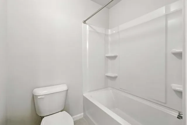 a white toilet sitting next to a bath tub