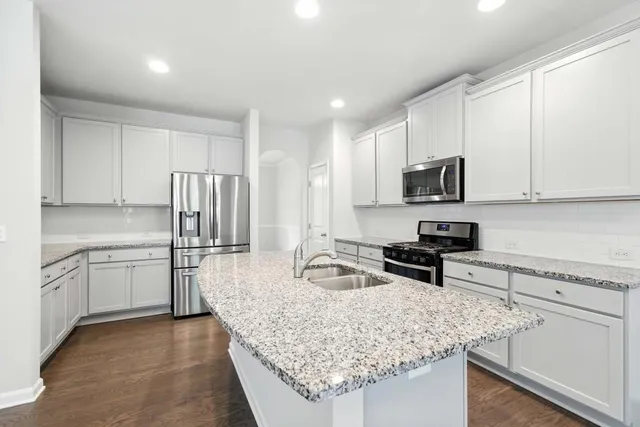 a kitchen with stainless steel appliances granite countertop a sink stove and refrigerator