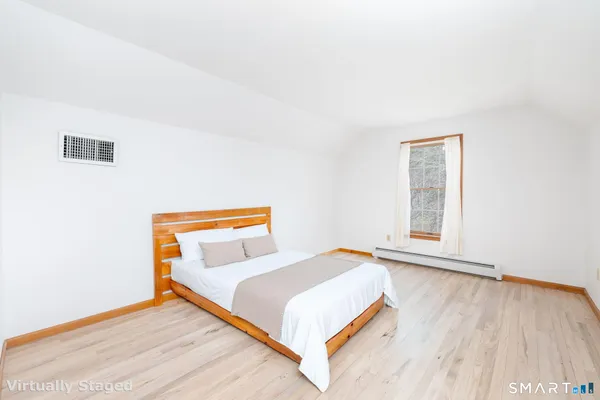 a bedroom with a bed and wooden floor