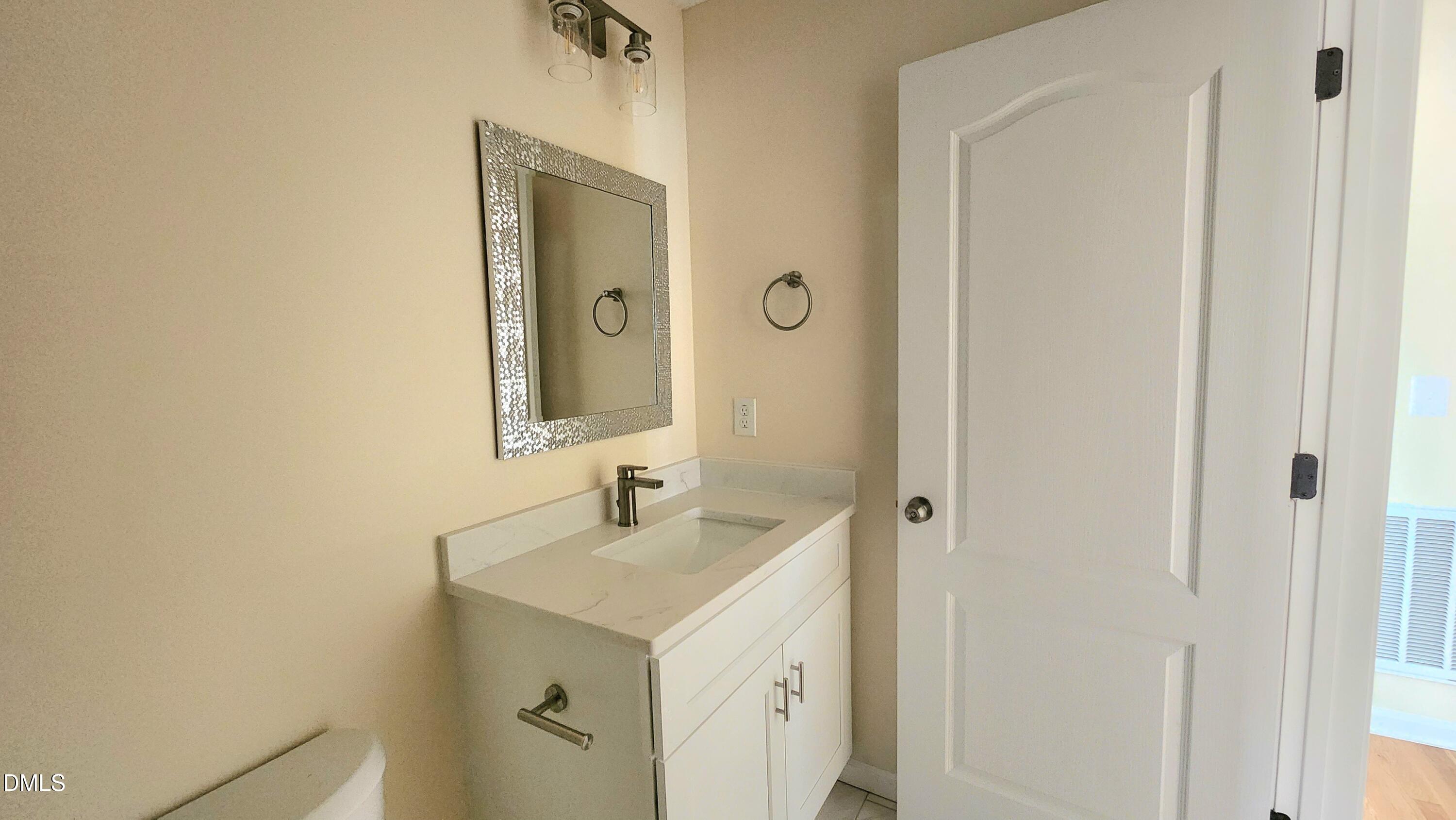 910 Ruby Street Durham, NC 27704 - Photo 11 of 16 a bathroom with a sink and a mirror