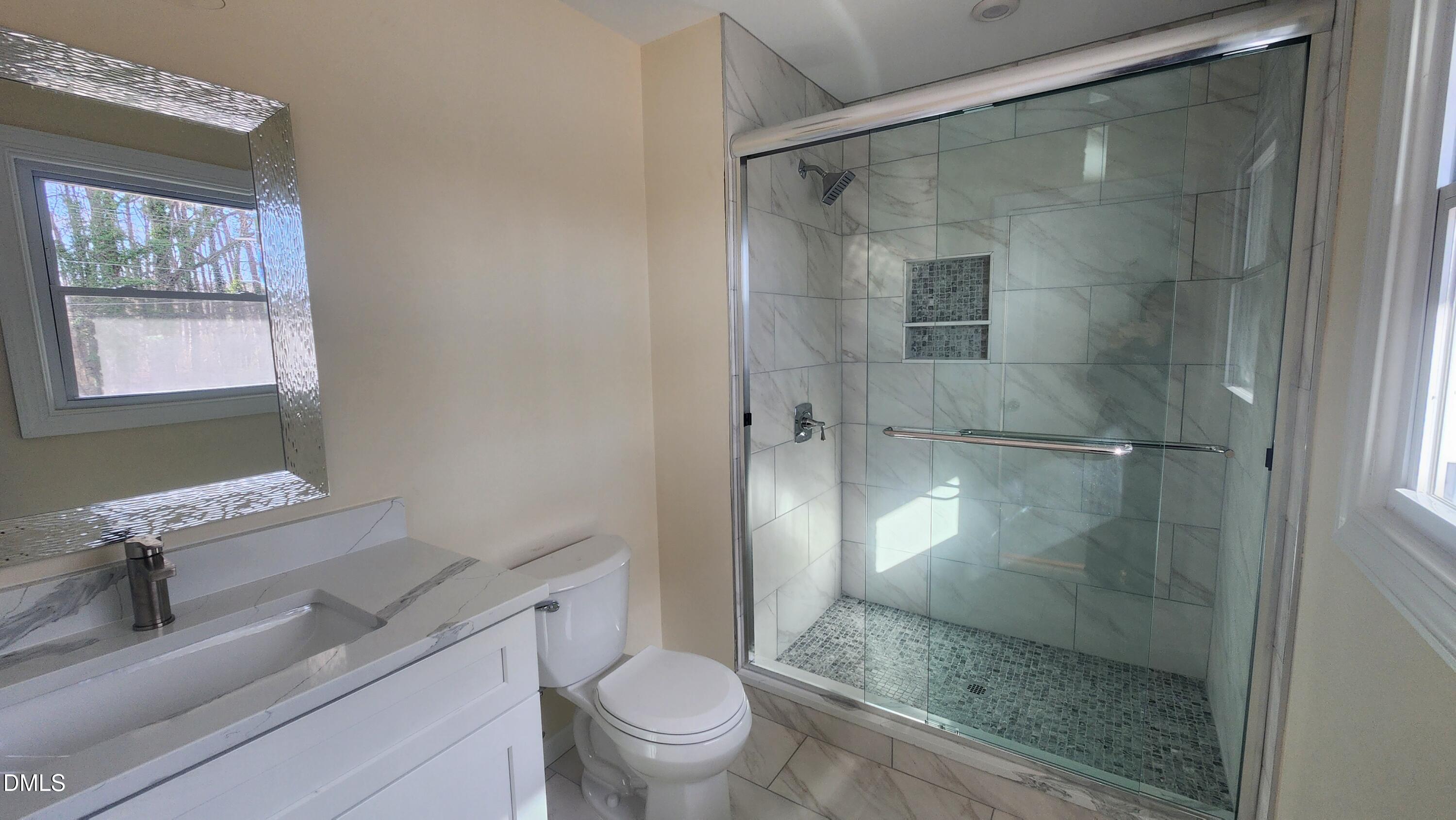 910 Ruby Street Durham, NC 27704 - Photo 15 of 16 a bathroom with a granite countertop bathtub shower sink mirror and toilet