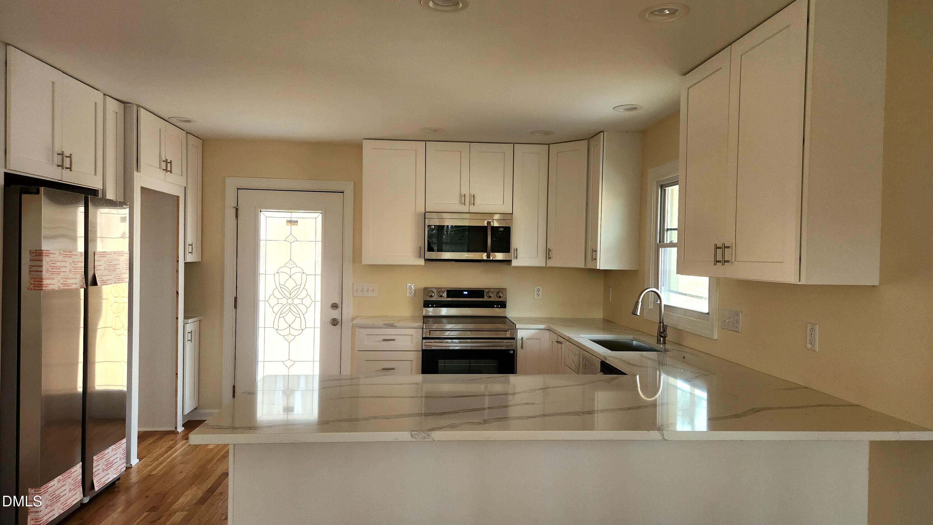 910 Ruby Street Durham, NC 27704 - Photo 3 of 16 a kitchen with stainless steel appliances granite countertop a refrigerator and a stove