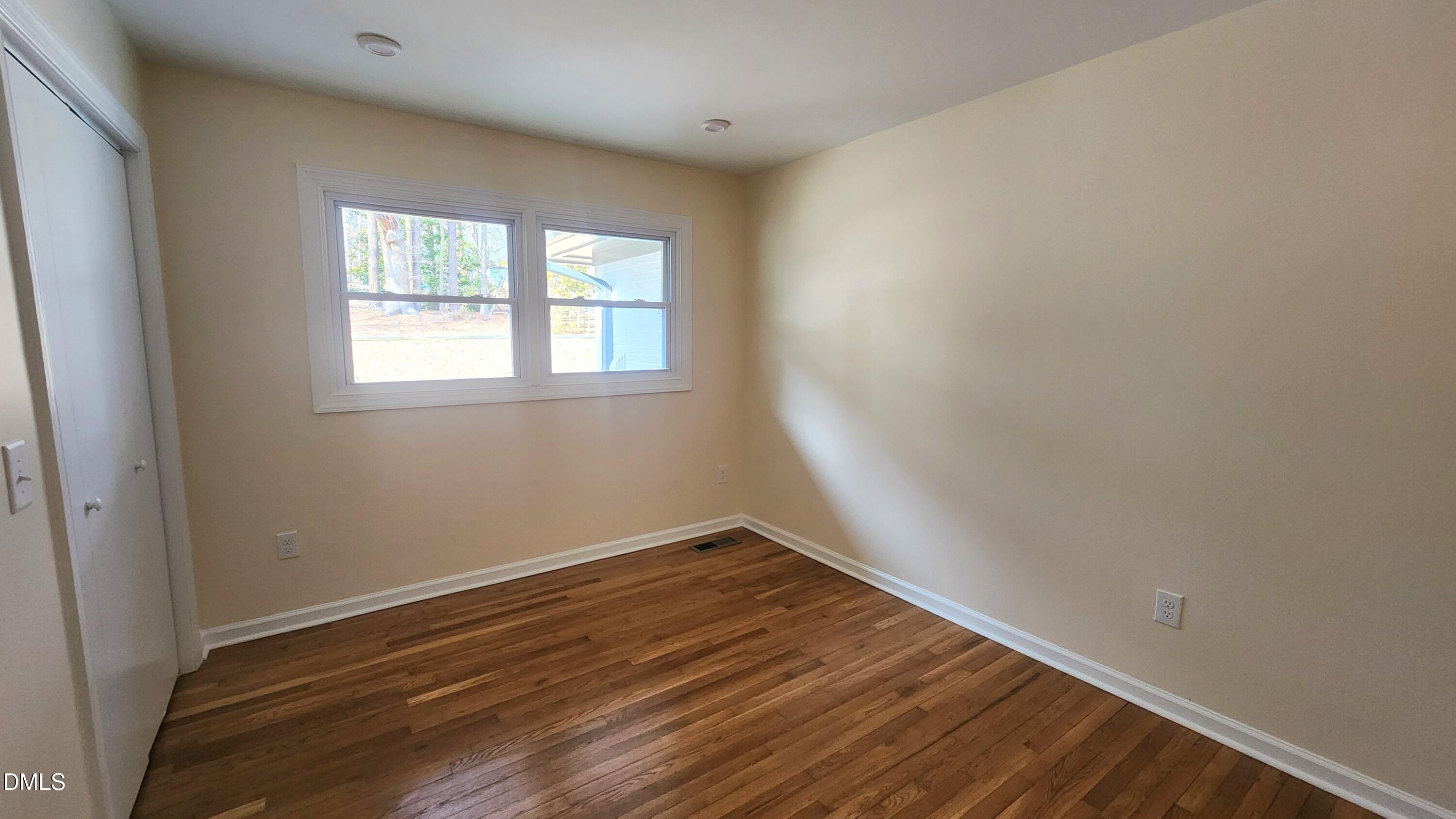 910 Ruby Street Durham, NC 27704 - Photo 7 of 16 an empty room with wooden floor and windows