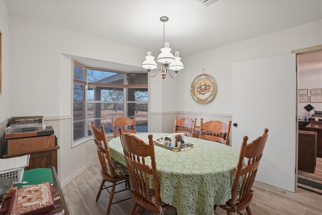 1309 Burleson Street George West, TX 78022 - Photo 11 of 32 a dining room with furniture a chandelier and wooden floor