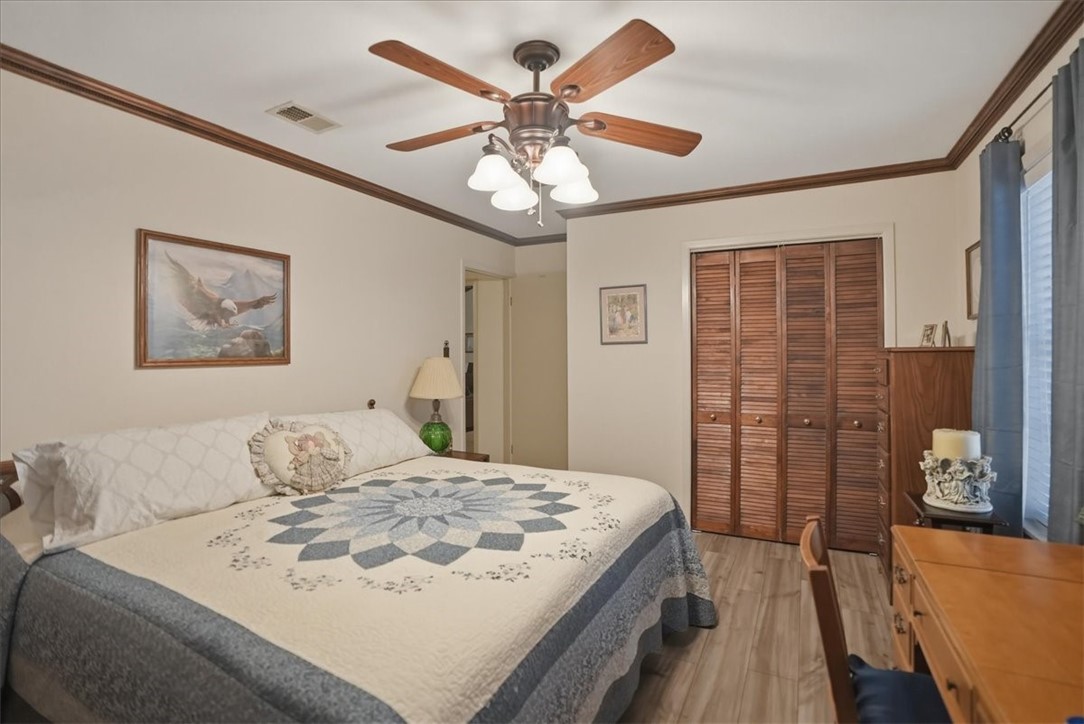 1309 Burleson Street George West, TX 78022 - Photo 16 of 32 a bedroom with a large bed and a chandelier