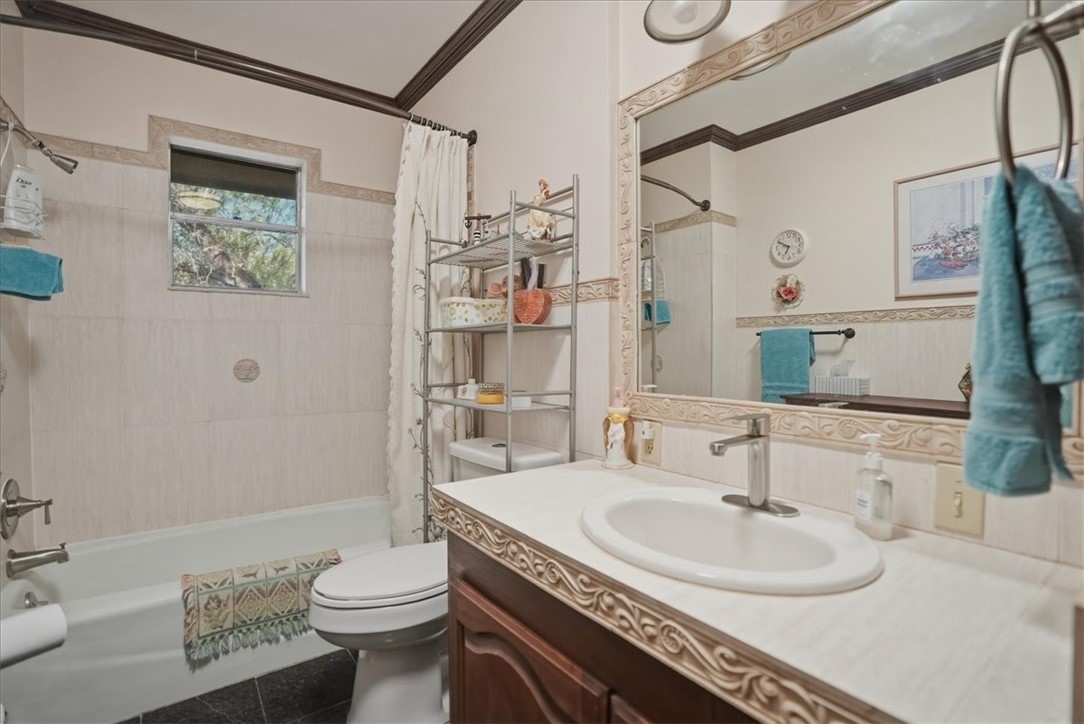 1309 Burleson Street George West, TX 78022 - Photo 18 of 32 a bathroom with a granite countertop sink toilet and shower