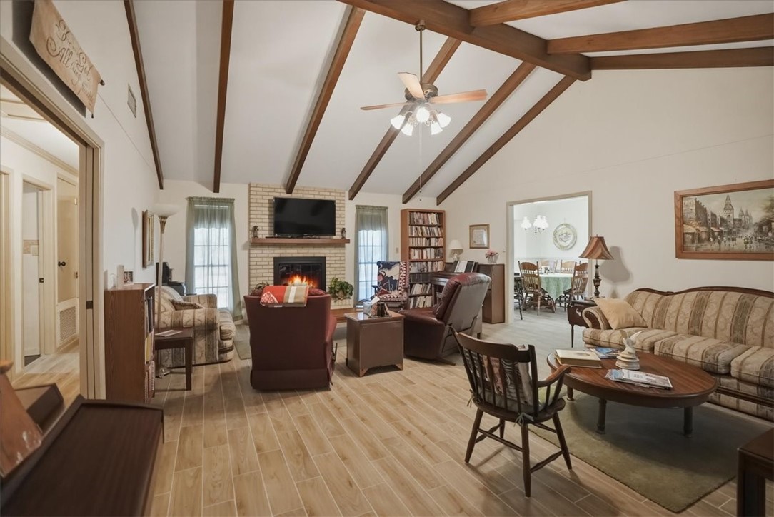1309 Burleson Street George West, TX 78022 - Photo 2 of 32 a living room with furniture a fireplace and a chandelier