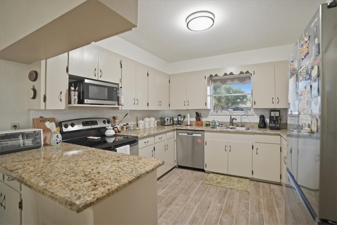 1309 Burleson Street George West, TX 78022 - Photo 7 of 32 a kitchen with sink cabinets and microwave