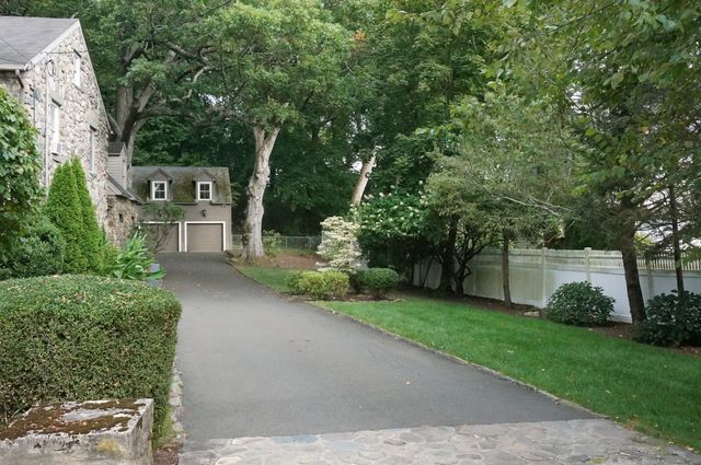 a front view of a house with a yard and trees