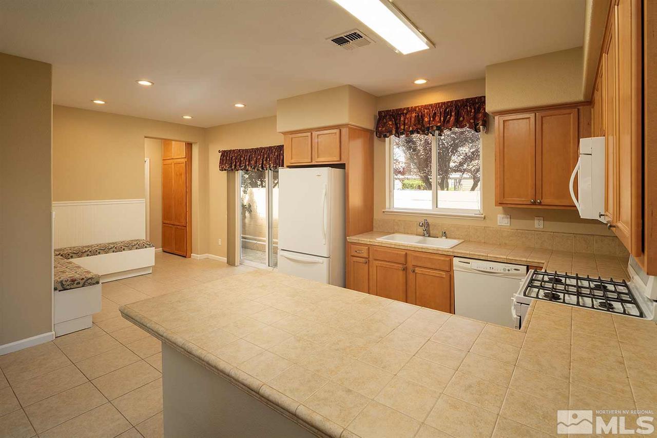 4599 Keyhaven Drive Reno, NV 89502 - Photo 3 of 28 a kitchen with a refrigerator sink and cabinets