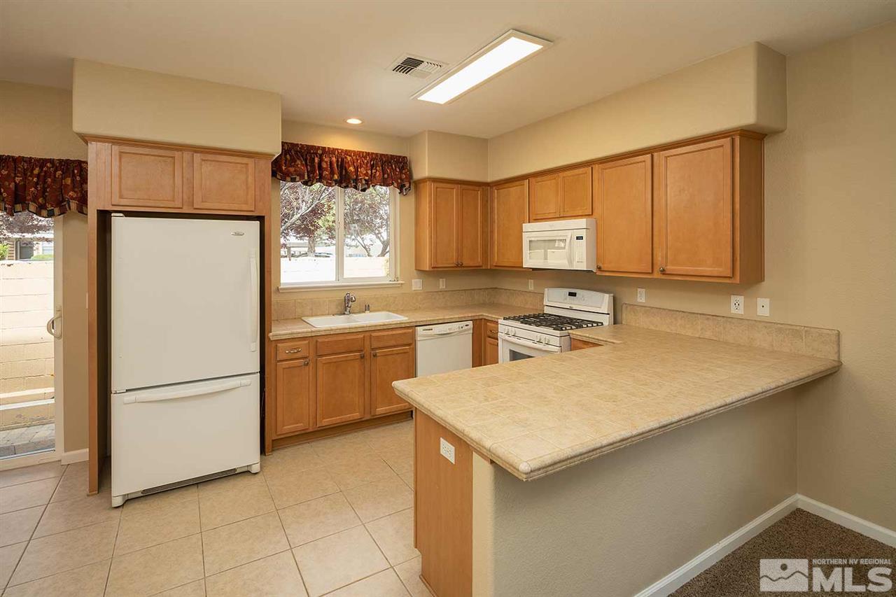 4599 Keyhaven Drive Reno, NV 89502 - Photo 6 of 28 a kitchen with a refrigerator a stove a sink and a oven