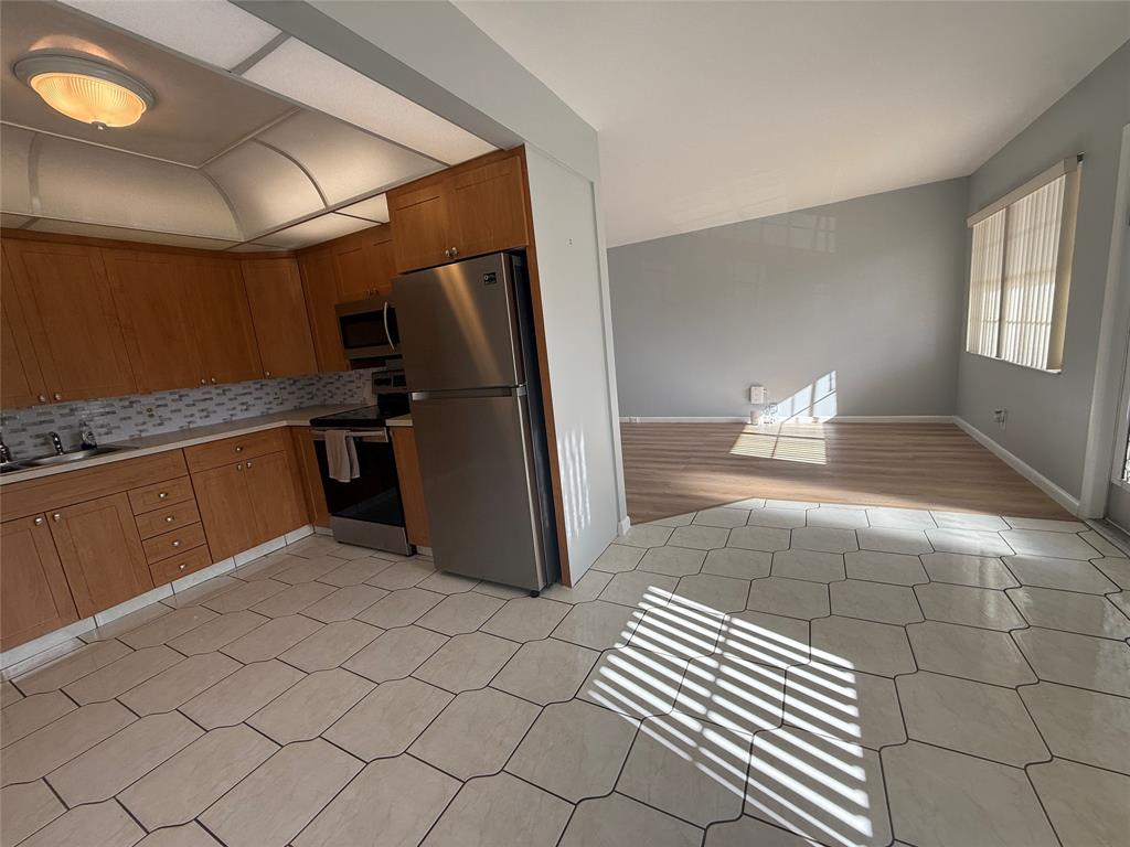 2017 Newcastle A, Unit 2017 Boca Raton, FL 33434 - Photo 13 of 41 a kitchen with stainless steel appliances a sink and a refrigerator