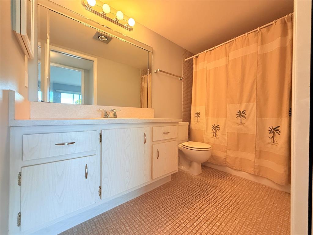 2017 Newcastle A, Unit 2017 Boca Raton, FL 33434 - Photo 18 of 41 a bathroom with a sink a toilet and shower