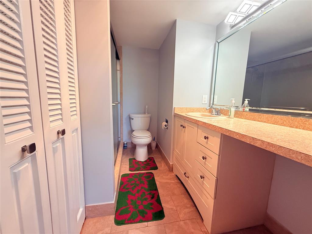 2017 Newcastle A, Unit 2017 Boca Raton, FL 33434 - Photo 22 of 41 a spacious bathroom with a toilet sink and a mirror