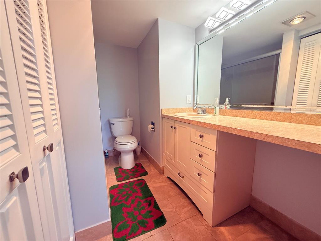 2017 Newcastle A, Unit 2017 Boca Raton, FL 33434 - Photo 23 of 41 a spacious bathroom with a toilet sink and a mirror