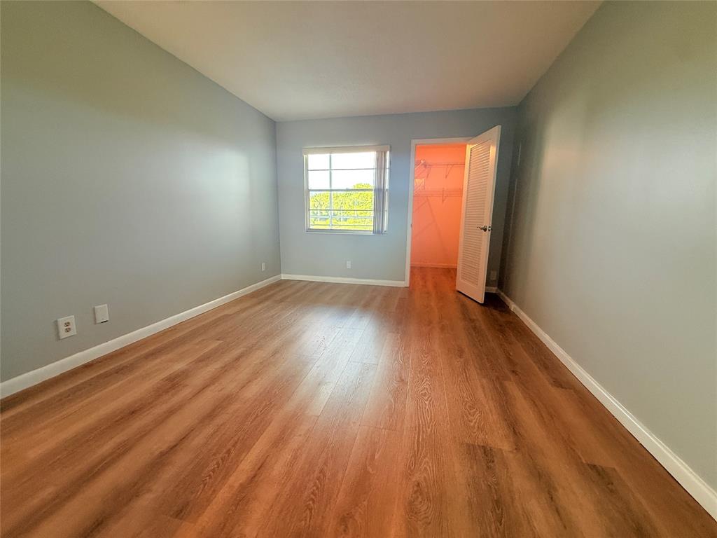 2017 Newcastle A, Unit 2017 Boca Raton, FL 33434 - Photo 27 of 41 an empty room with wooden floor and windows