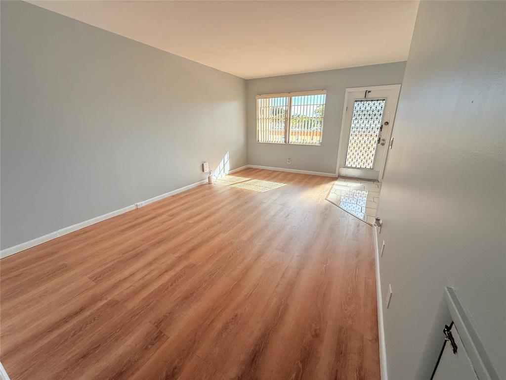 2017 Newcastle A, Unit 2017 Boca Raton, FL 33434 - Photo 37 of 41 an empty room with wooden floor and windows