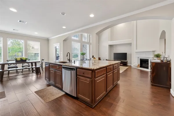 a kitchen with granite countertop wooden cabinets stainless steel appliances and wooden floor