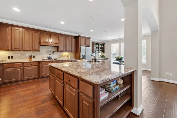 a kitchen with stainless steel appliances granite countertop a stove top oven a sink a counter space and cabinets