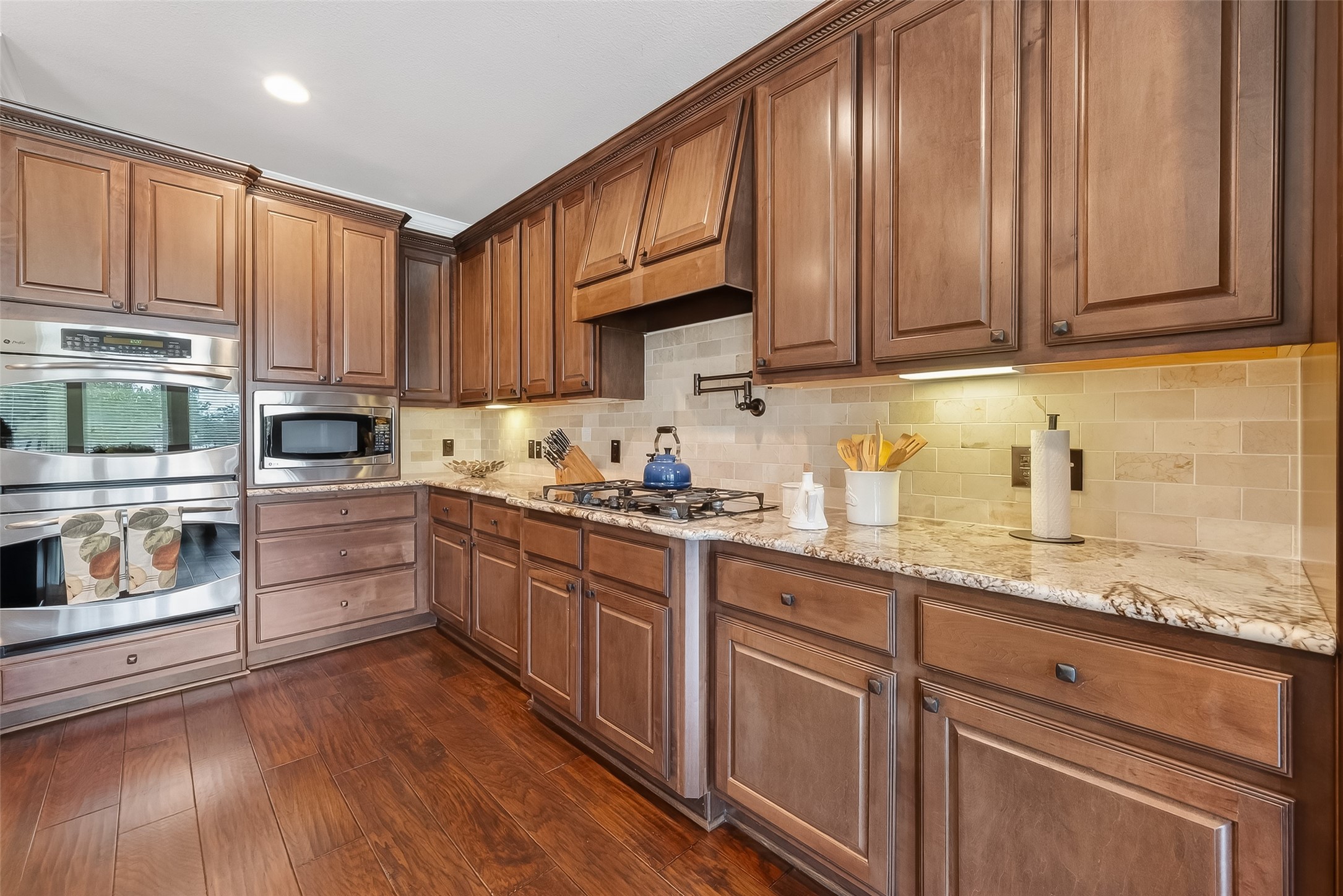 10 Cayuga Pond Court Spring, TX 77389 - Photo 17 of 50 a kitchen with granite countertop wooden cabinets stainless steel appliances and wooden floor
