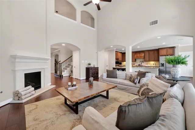 a living room with furniture a fireplace and a chandelier fan