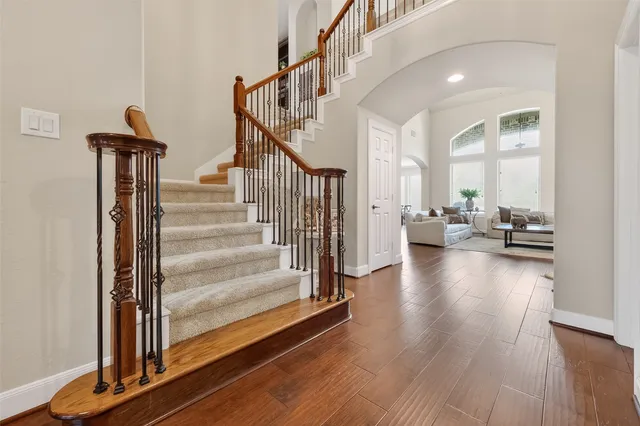 a view of a hallway with wooden floor and staircase
