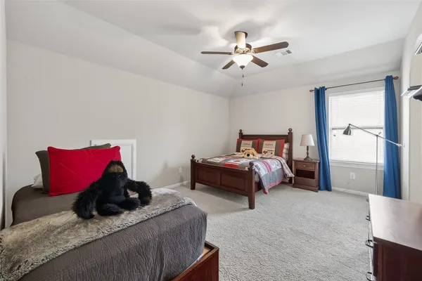 a bedroom with a white bed cabinets and a window