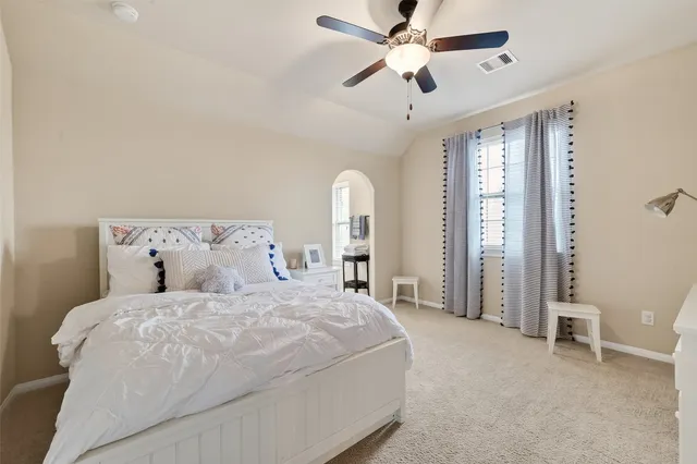 a spacious bedroom with a bed and a chandelier