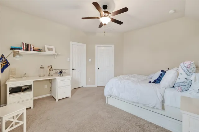 a bedroom with a white bed cabinets and a window