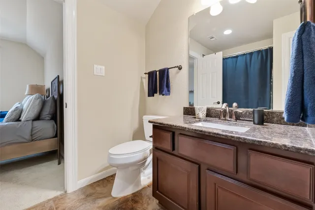 a spacious bathroom with a granite countertop sink a toilet and a mirror