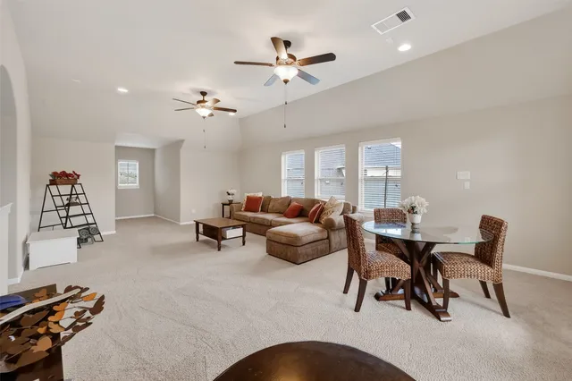 a living room with furniture a chandelier and a window