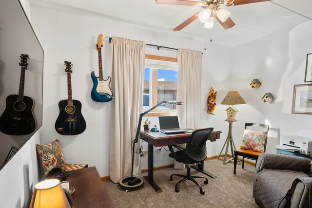 a view of a workspace with furniture and a window