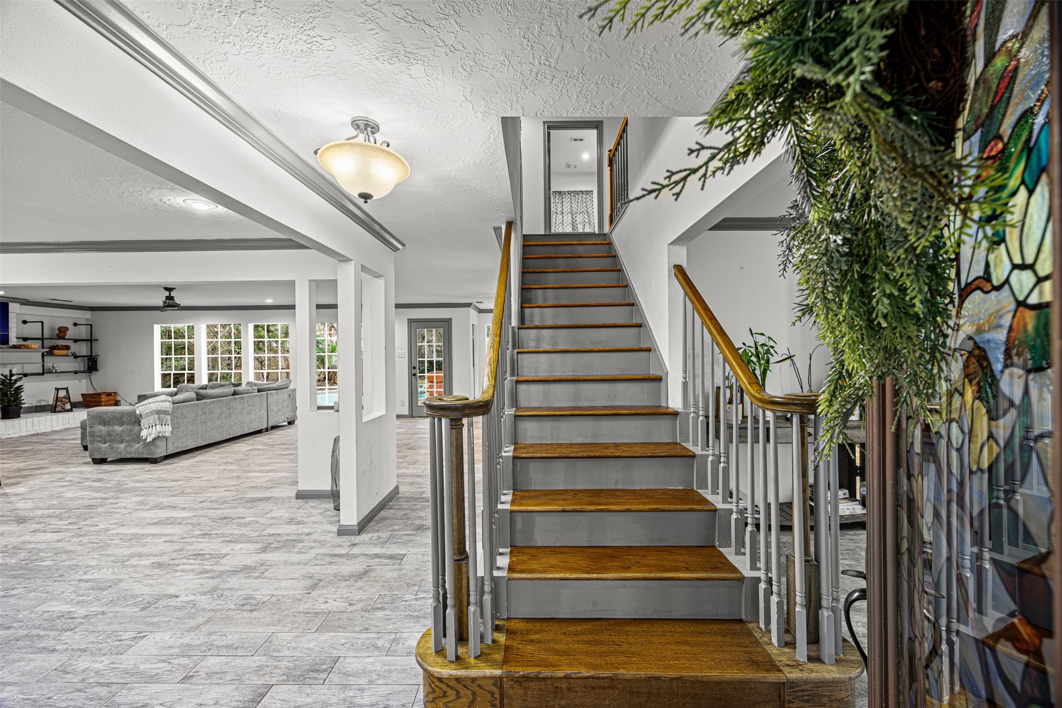 6511 Elmgrove Road Spring, TX 77389 - Photo 19 of 33 This photo showcases a bright, open-concept living space with a modern staircase featuring wooden steps and white railings.