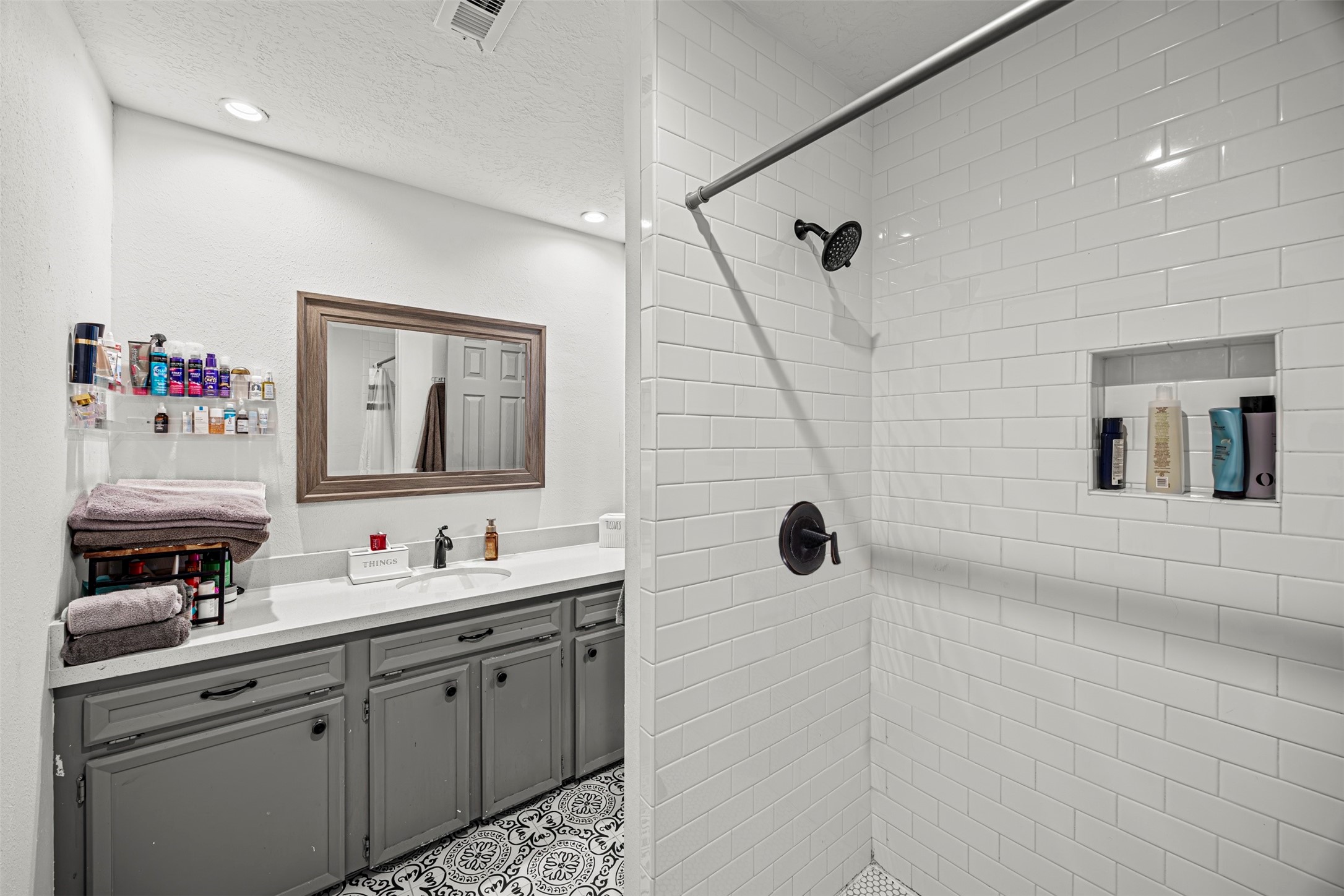 6511 Elmgrove Road Spring, TX 77389 - Photo 21 of 33 This bathroom features a modern design with a spacious walk-in shower, white subway tiles, and a built-in shelf.