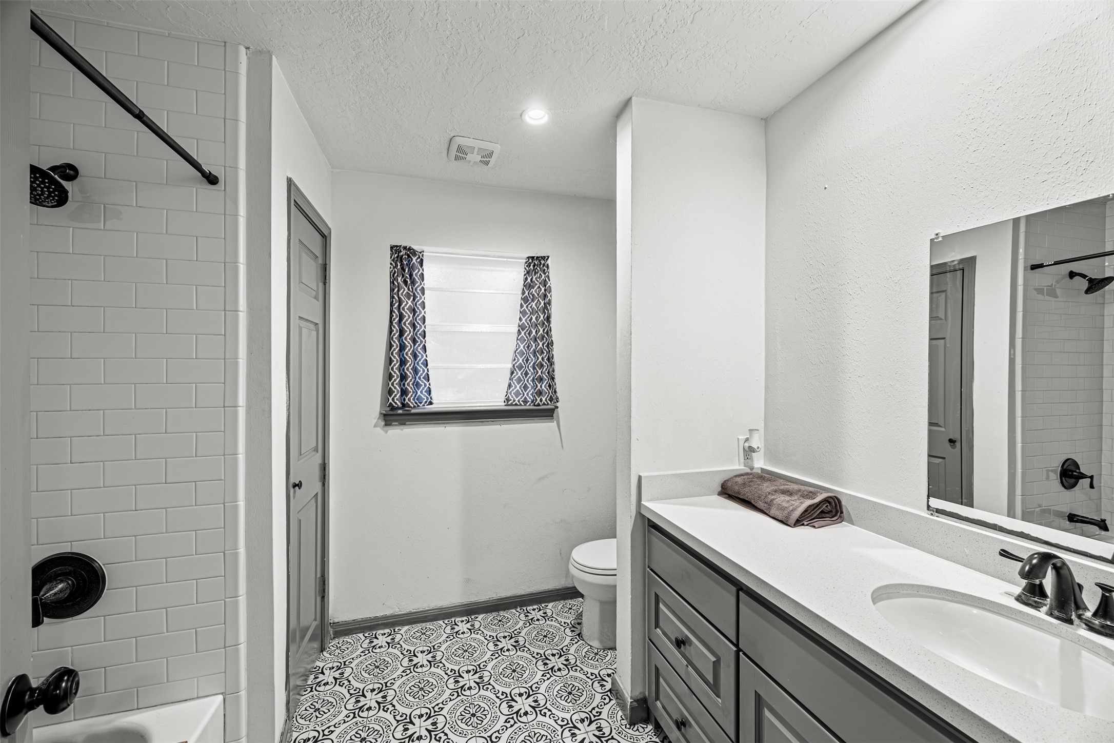 6511 Elmgrove Road Spring, TX 77389 - Photo 24 of 33 Bathroom includes a large vanity with dual sinks, a framed mirror, and ample storage space, complemented by patterned floor tiles.