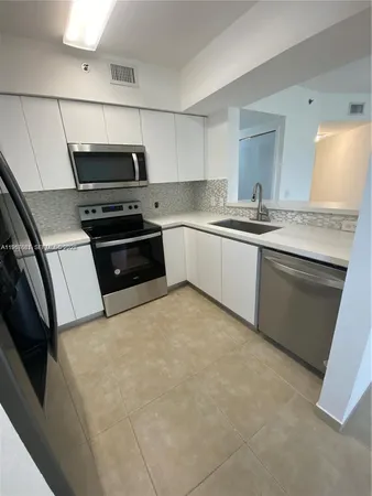 a kitchen with granite countertop a stove microwave and sink
