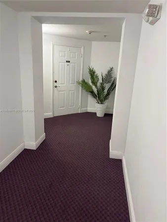 a view of a livingroom and an empty room with a fireplace