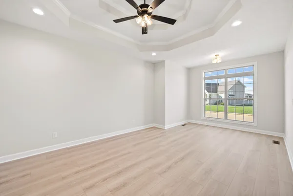 an empty room with a window and a ceiling fan