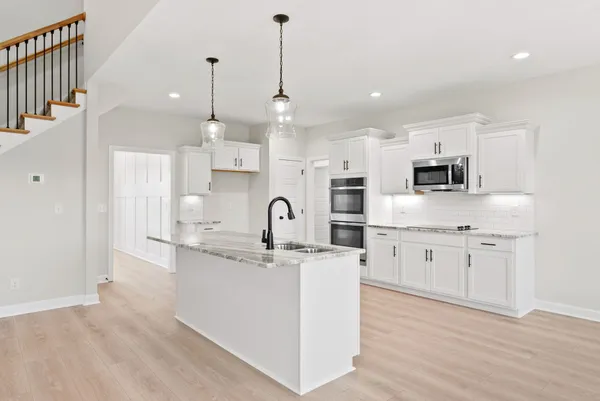 a kitchen with granite countertop a sink stove and refrigerator