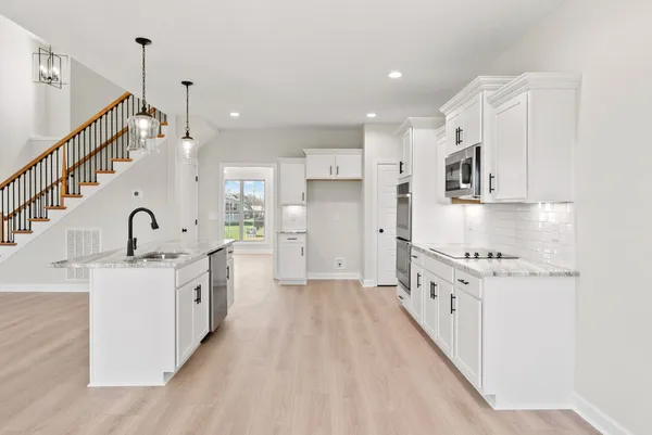 a large kitchen with kitchen island a sink stainless steel appliances and cabinets