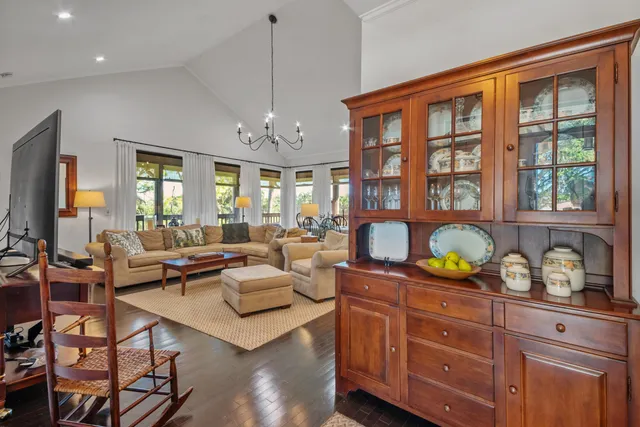 a living room with furniture a chandelier and a flat screen tv